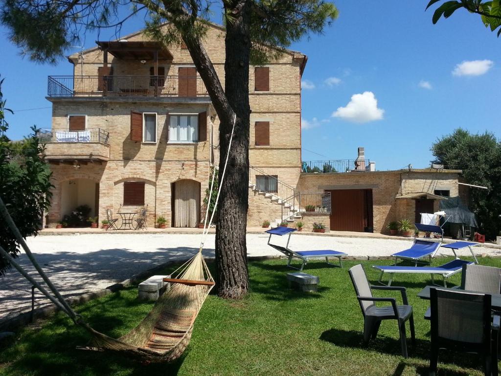 CossignanoAgriturismo Galanti的前面有树和吊床的房子