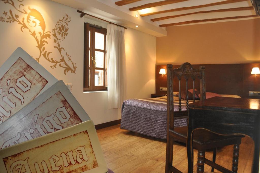 圣多明各德拉El Molino de Floren的卧室配有一张床和一张桌子及椅子