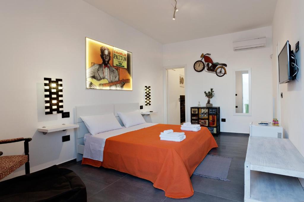 托雷拉皮罗Bed & Blues的一间卧室配有一张带橙色毯子的床