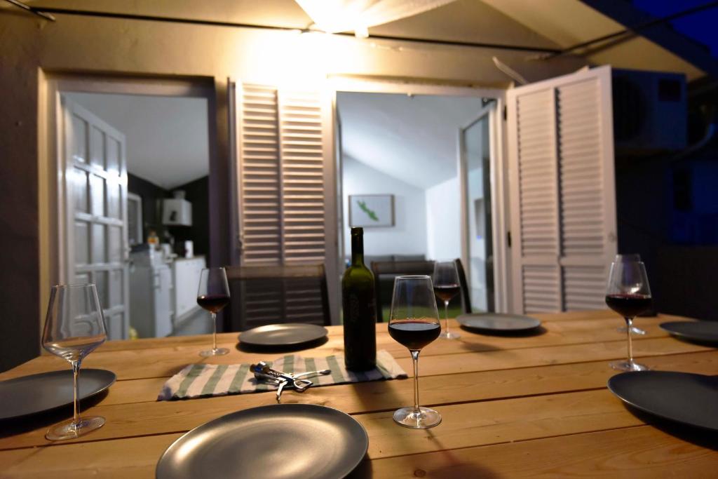 贝蒂纳Apartmani Vinetan的一张带酒杯和一瓶葡萄酒的木桌