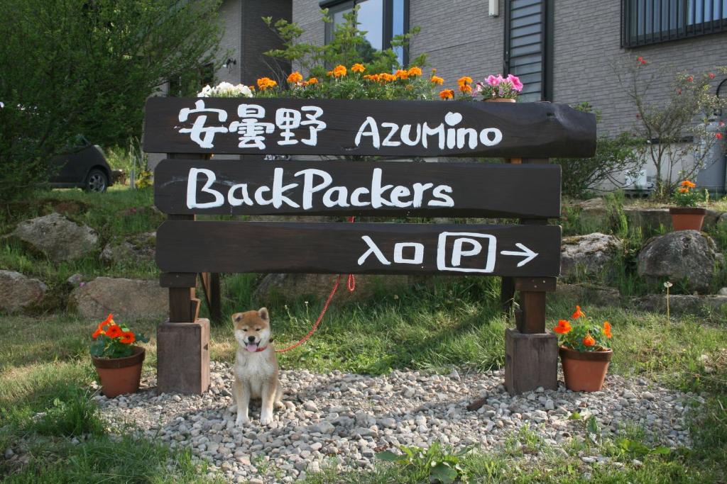 Matsukawa安昙野背包客旅馆的一只狗在绳子上,站在标志下