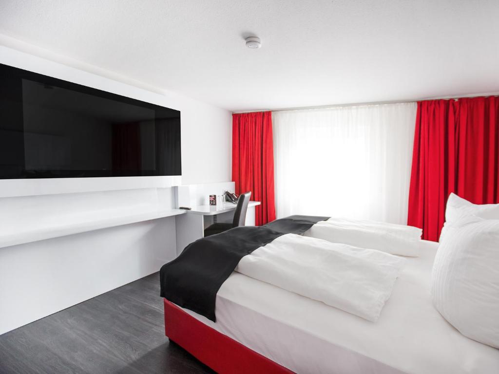 菲林根-施文宁根多尔美罗菲林根施文宁根酒店的酒店客房,设有一张带平面电视的床铺。