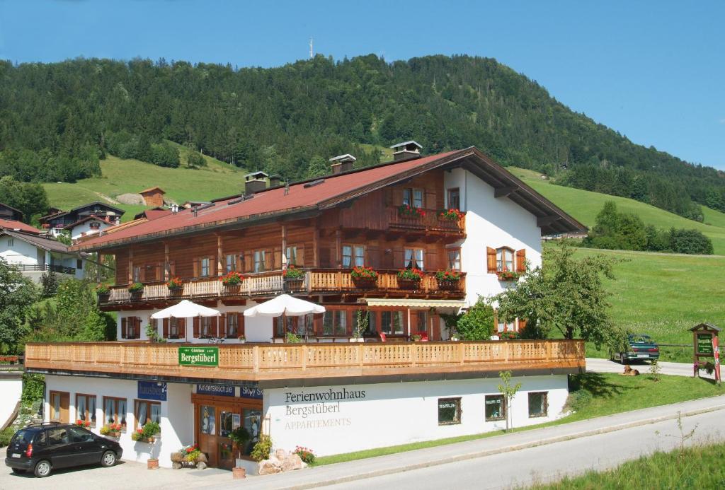 雷特温克尔博格斯图博旅馆的一座位于山丘上并设有阳台的大型木质建筑