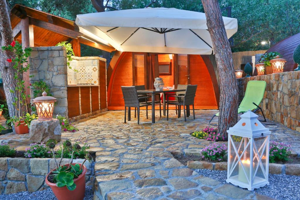 切法卢坎佩吉欧圣菲利波酒店的庭院配有遮阳伞和桌椅。