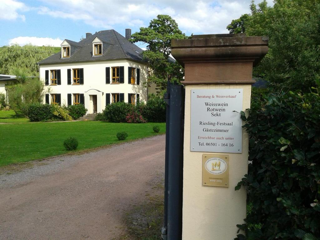 Wiltingen魏茵古特施密茨 - 西蒙酒店的白色房子前面的标志