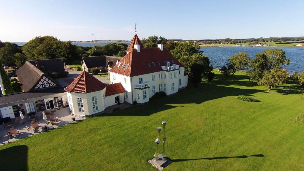 埃伯鲁普Gl. Avernæs Sinatur Hotel & Konference的草场上白色大房子的空中景色