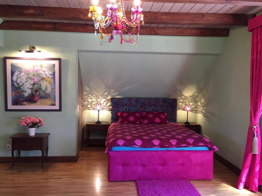 斯伽尔达Peahen Residence的一间卧室配有粉红色的床和吊灯。