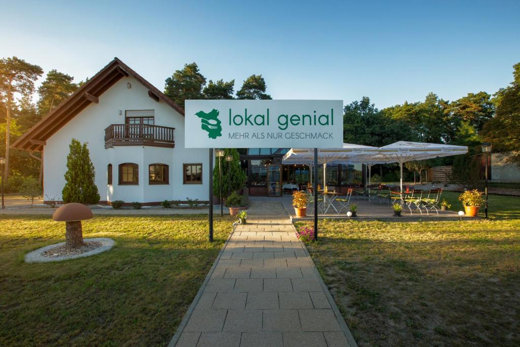 贝利茨Lokal Genial Pension & Restaurant的大楼前的酒店标志