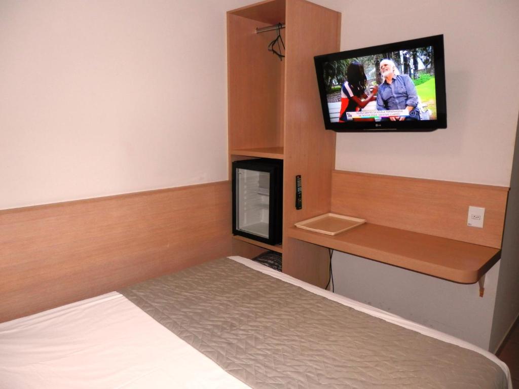 卡坦杜瓦Hotel Lider - Catanduva的一间设有床铺和墙上电视的客房