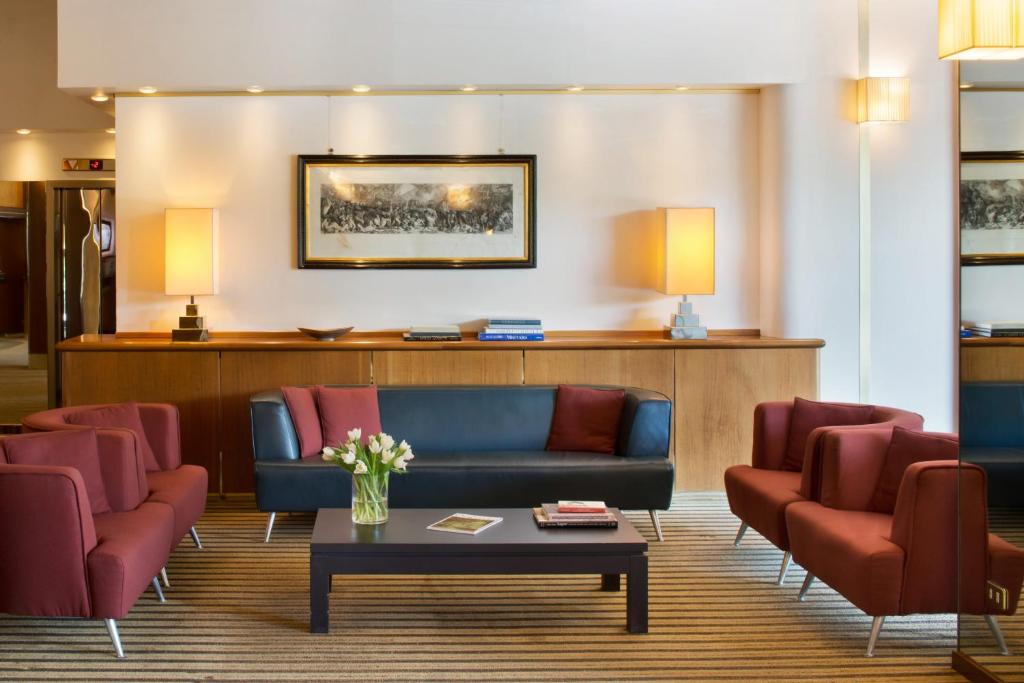 贝加莫星际克里斯塔罗宫酒店的一间设有蓝色沙发和红色椅子的等候室