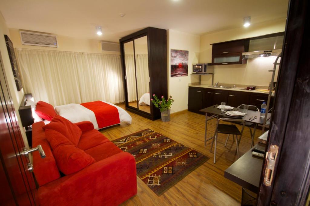 开罗NewCity Hotel & Suites的酒店客房,配有一张床和一张红色的沙发