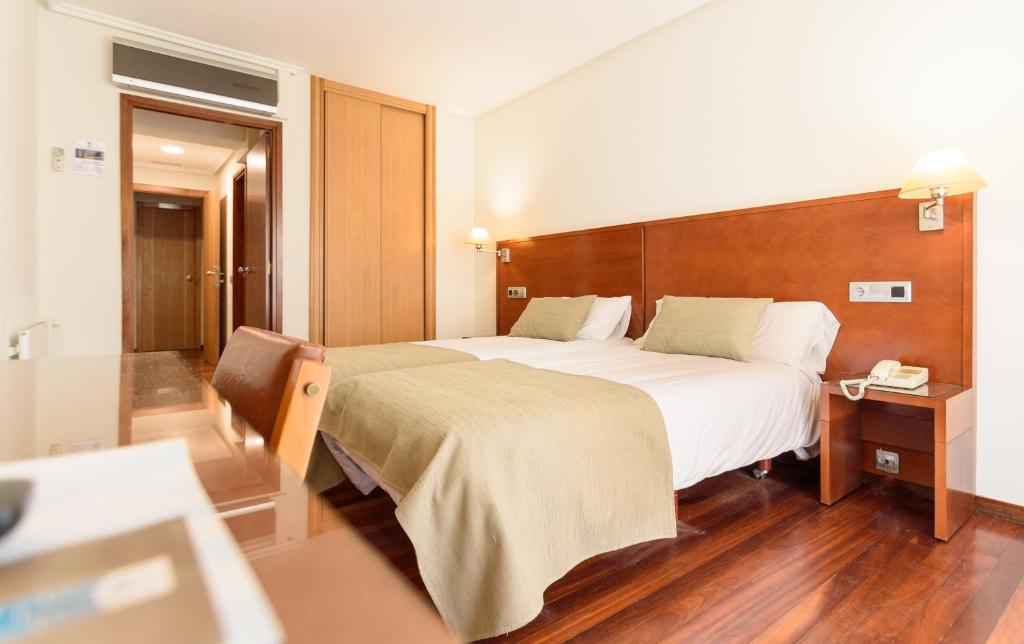圣地亚哥－德孔波斯特拉墨西哥PR酒店的配有一张大床和一部电话的酒店客房