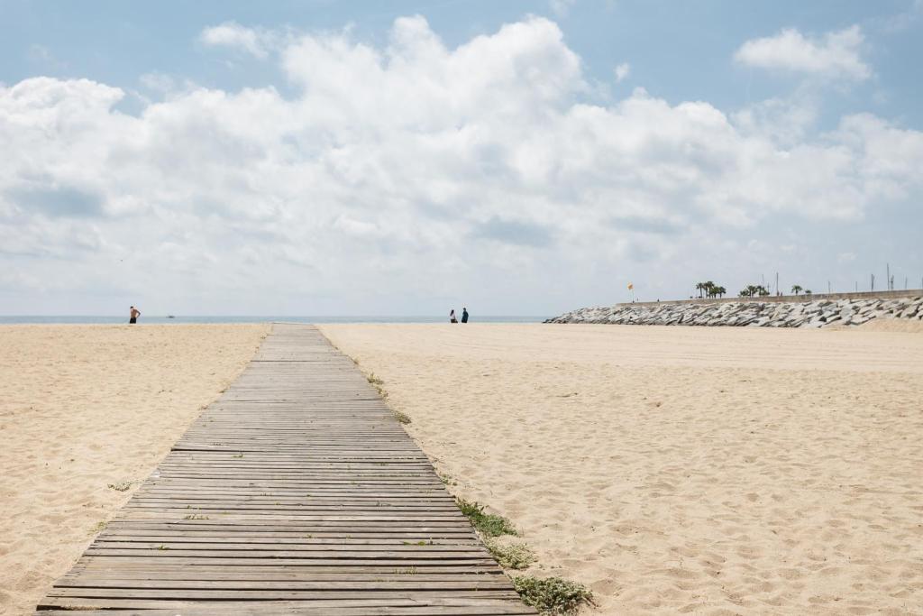 滨海比拉萨尔Vilasardemarlux1的一条与远处人们在沙滩上的木路