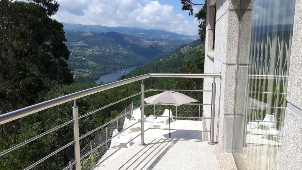 拜昂Casa Douro Terrace的阳台配有桌子和雨伞。