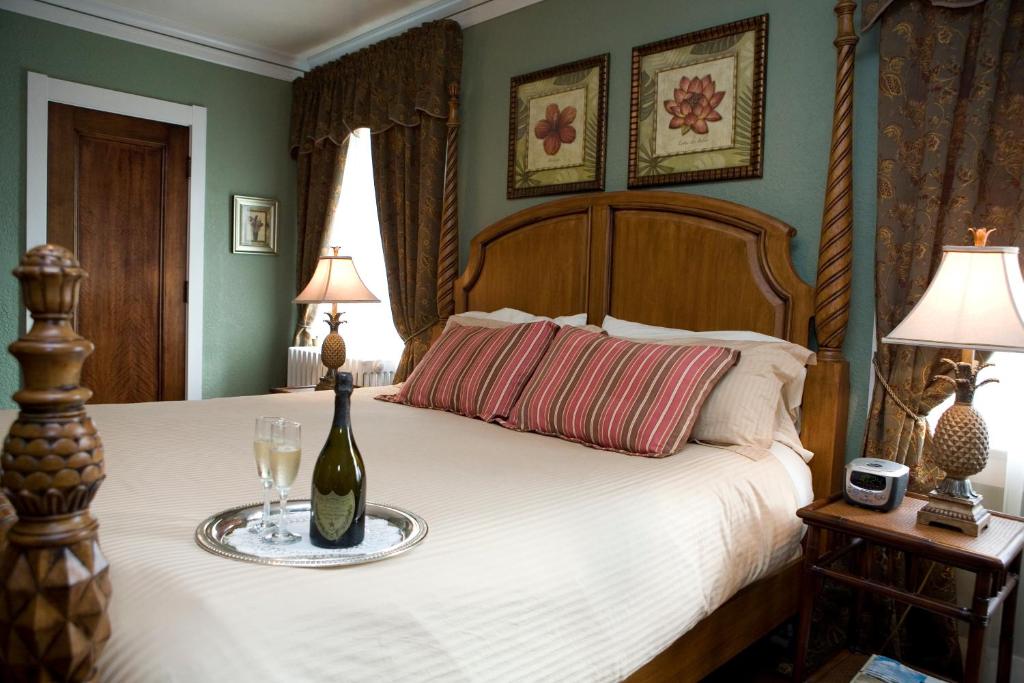 索格塔克The Belvedere Inn & Restaurant的一间卧室配有一张带一瓶和一杯的床铺