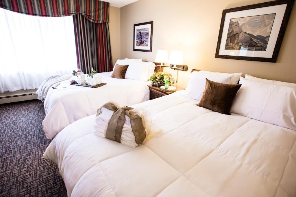 朱诺Ramada by Wyndham Juneau的配有白色枕头的酒店客房内的两张床