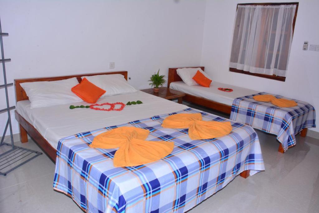 亭可马里宜人公园假日酒店的两张位于房间的床,上面有橙色毛巾