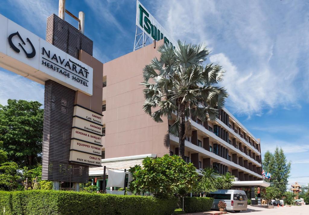 甘烹碧娜华拉传承酒店的前面有棕榈树的建筑