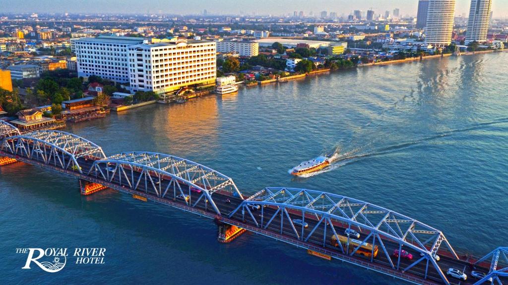 曼谷皇家河畔酒店的一条河上的桥梁,有船