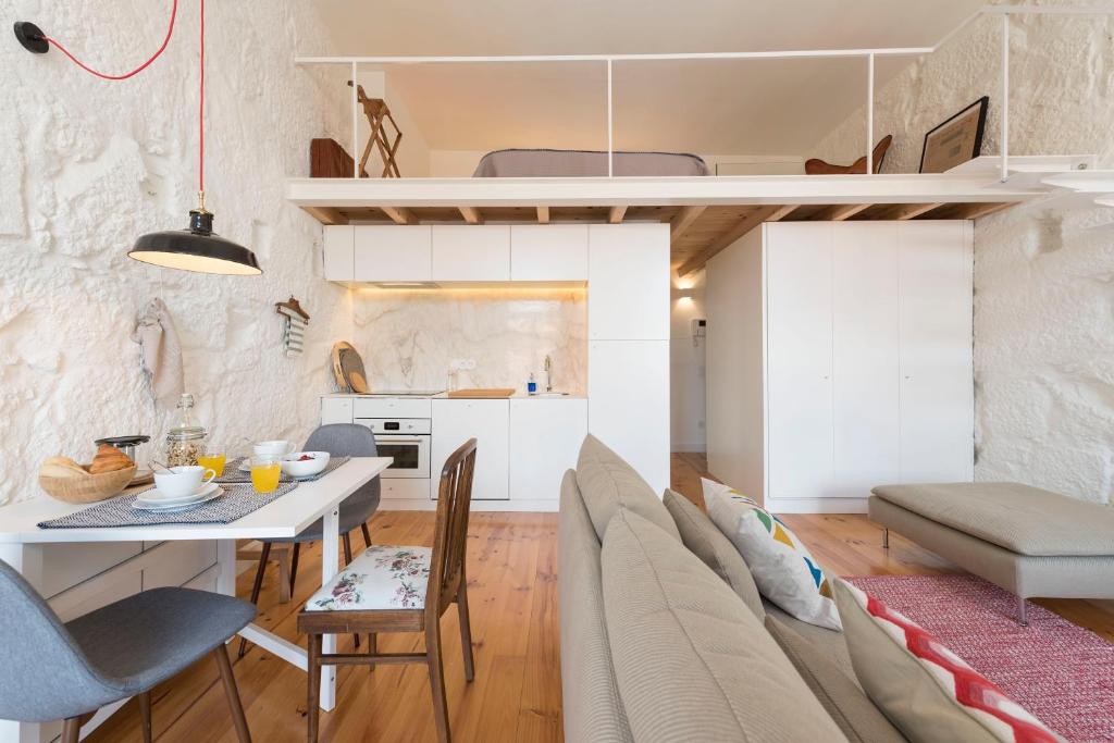 波尔图LovelyStay - Cativo Mezzanine Studio的厨房以及带桌椅的起居室。