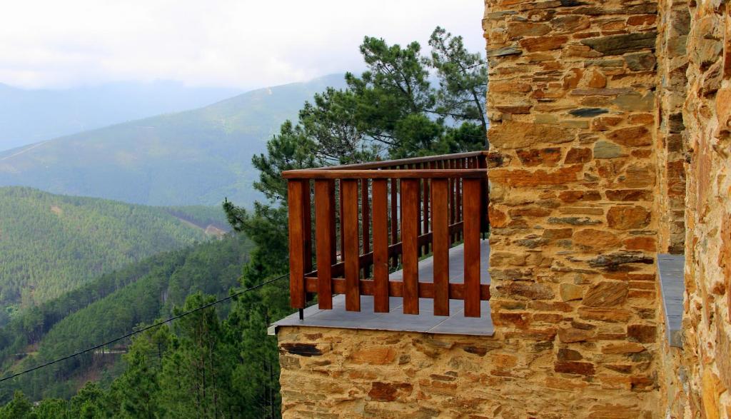 奥利维拉多霍斯比托Quinta Do Caramulo的阳台位于一栋以山脉为背景的建筑的一侧