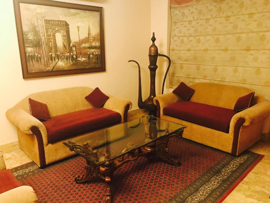 新德里天悦套房住宿加早餐酒店的客厅配有两张沙发和一张咖啡桌
