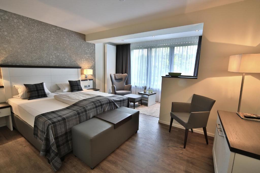 巴特伊堡弗雷登兰迪伊尔酒店的一间卧室配有一张床、一张桌子和一把椅子