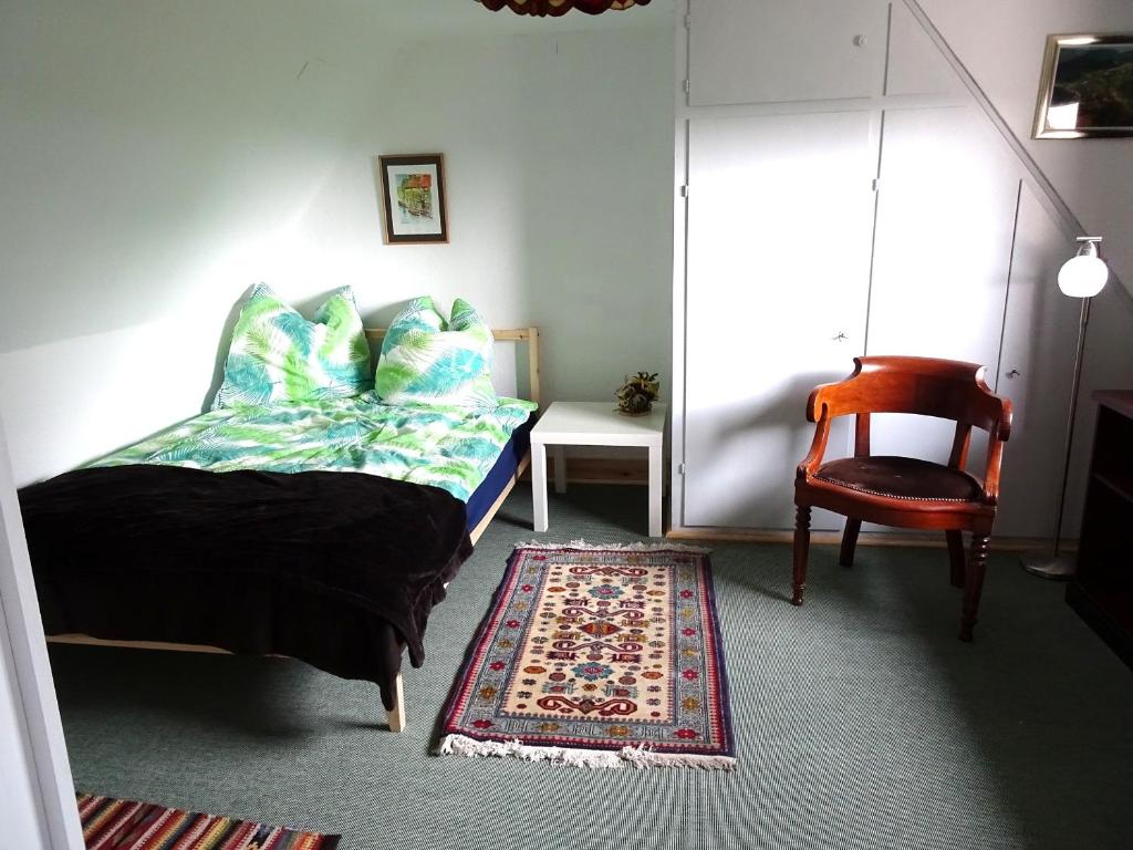 韦黑幕斯菲尔德Haus Fermate的一间卧室配有一张床、一把椅子和地毯