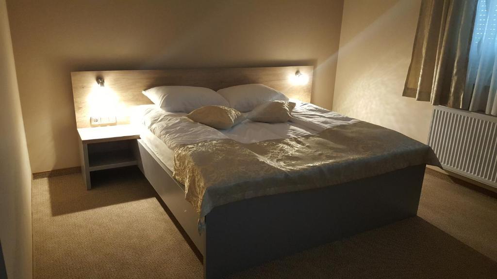 比哈奇Rooms Comfor的卧室内的一张带两个枕头的床和一个床头柜