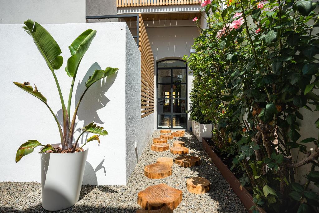 休达德亚Sodium Boutique Hotel的庭院里种植了植物,设有木凳