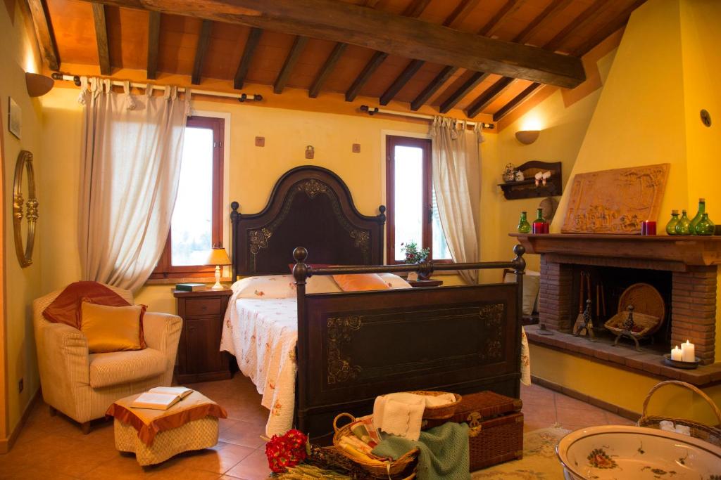 拉里Il Frutteto的一间卧室设有一张大床和一个壁炉
