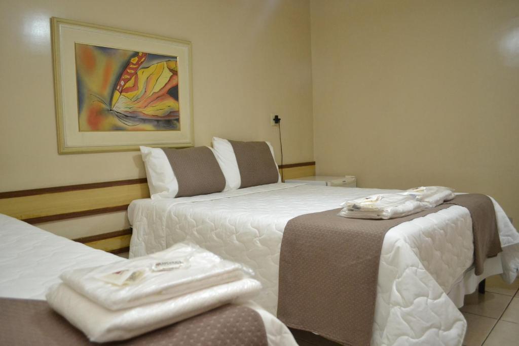 伊帕廷加Domus Hotel Veneza Ipatinga的酒店客房,配有两张带毛巾的床
