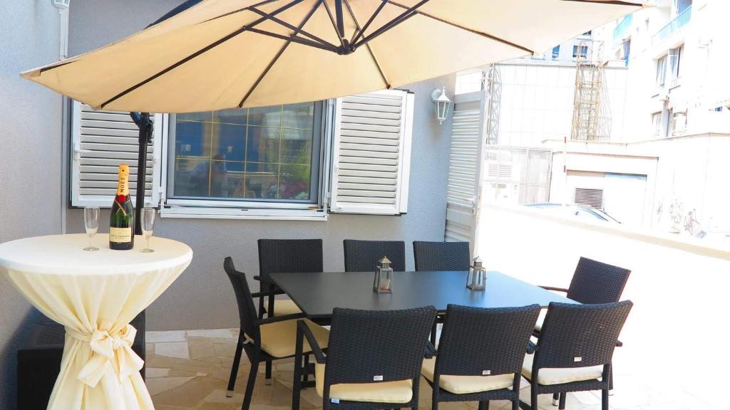 斯普利特Superior Apartment CASA SPALATO的一张桌子和椅子,一把雨伞放在房间里