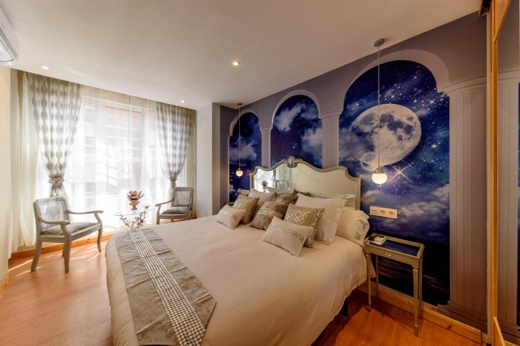 乌迪亚莱斯堡德卡斯特罗别墅酒店的一间卧室配有一张带月亮壁画的大床