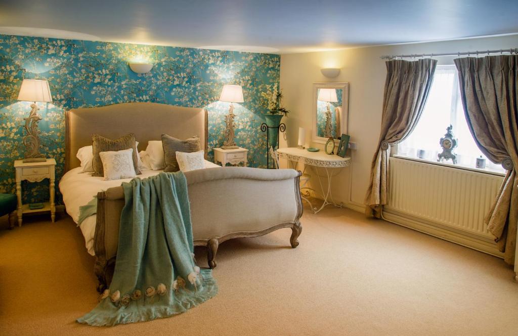 贝尔顿The Queens Head的一间卧室设有一张床和一个大窗户
