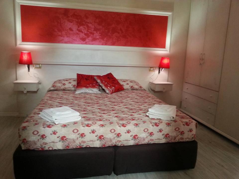 夸尔图-圣埃莱娜La Fontanella的一间卧室配有一张带两个红色枕头的床