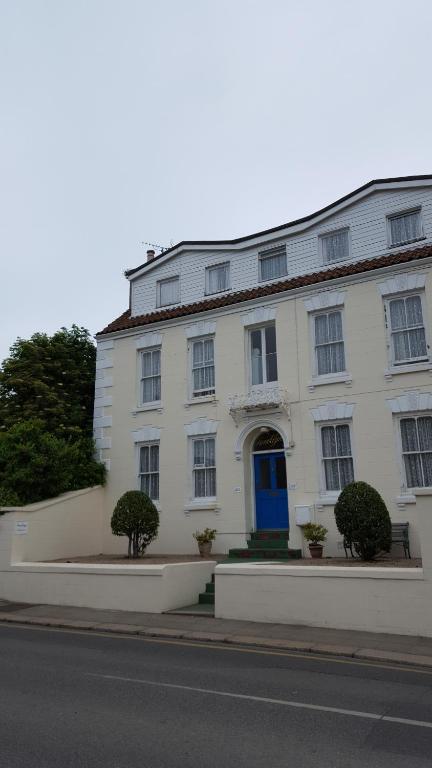 圣赫利尔泽西Franklyn Guesthouse的一条白色的建筑,在街上有一扇蓝色的门