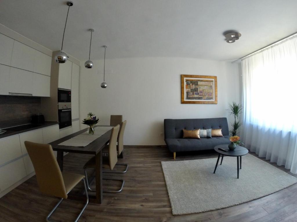 布达佩斯英雄之家公寓的客厅配有桌子和蓝色沙发