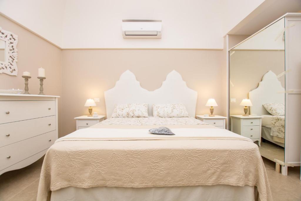 莫诺波利Casa Velia的白色卧室设有一张大床和镜子