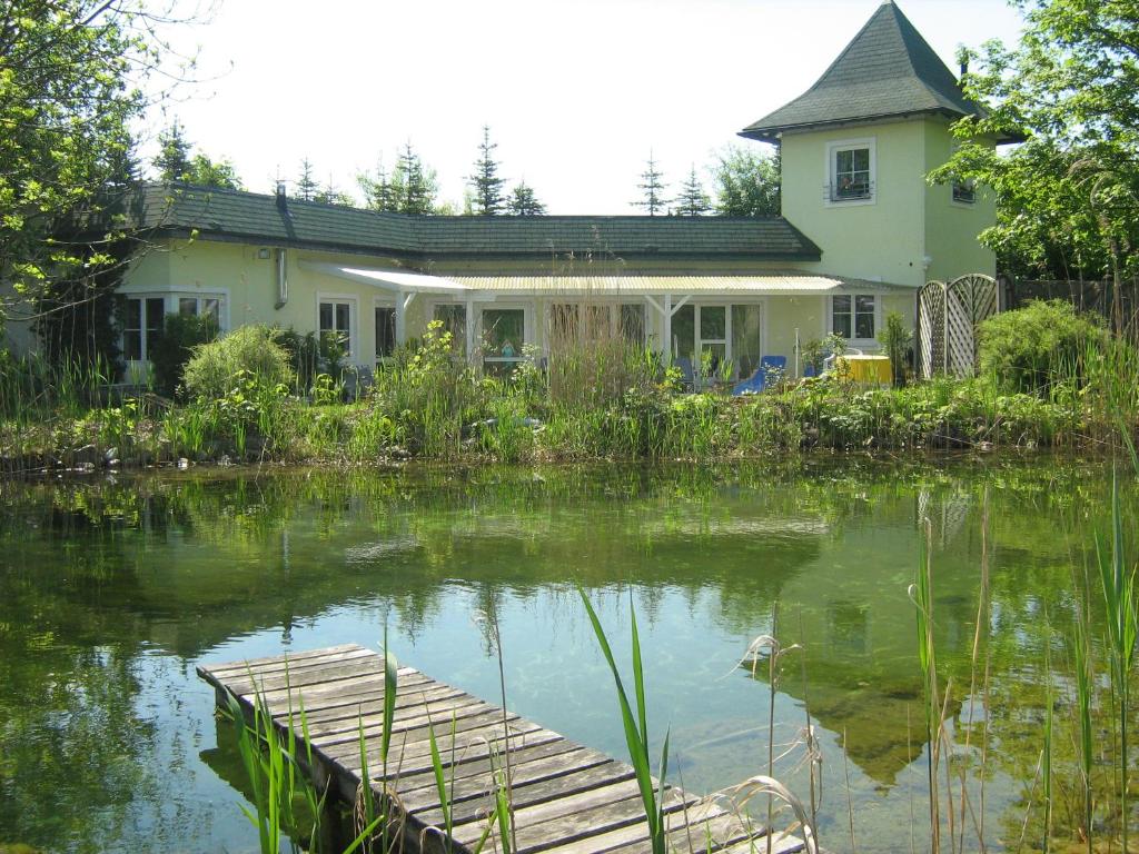 瓦勒湖畔诺伊马克特Gasthaus Eggerberg的前面有池塘的房子