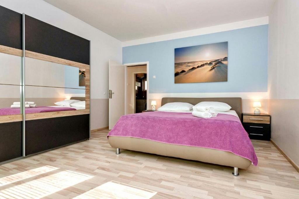 斯普利特Apartment Maja的一间卧室设有一张大床和一个大镜子