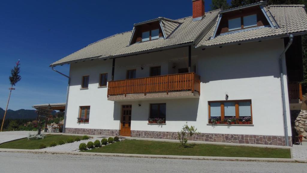 索尔察瓦TURISTIČNA KMETIJA STREVC的白色房子的一侧设有阳台
