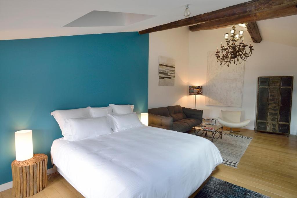 勒布伊Les Apparts du Plot的卧室配有一张白色大床和蓝色的墙壁