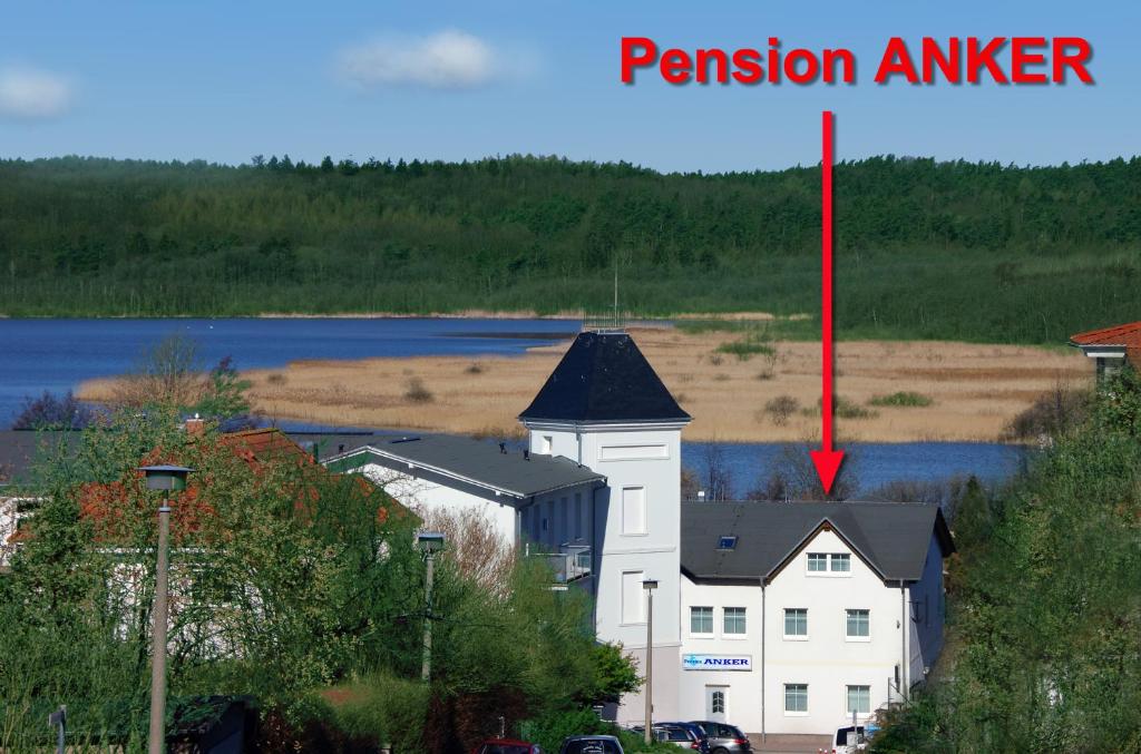 宾茨Pension Anker的一座白色的建筑,上面有一根红杆