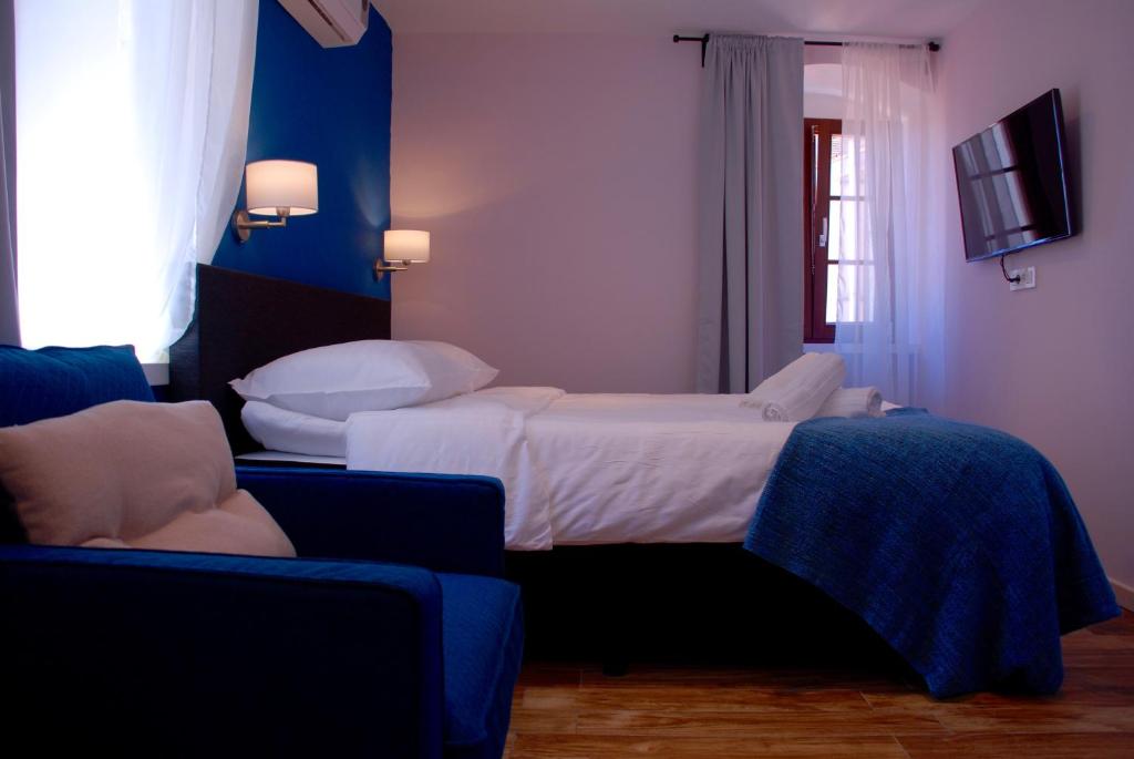 里耶卡Old Town Inn的一间卧室配有一张床、一台电视和一张沙发
