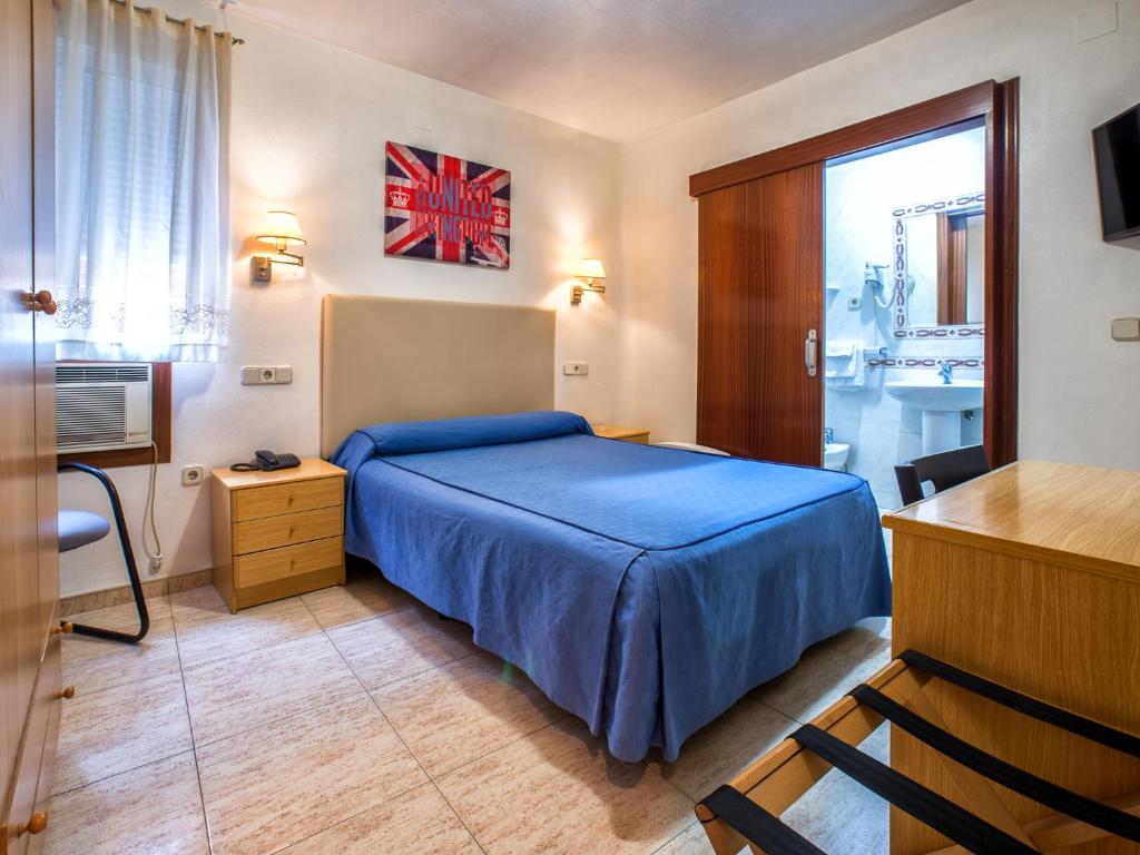 穆尔西亚莱加斯皮酒店的一间卧室配有蓝色的床和一张书桌