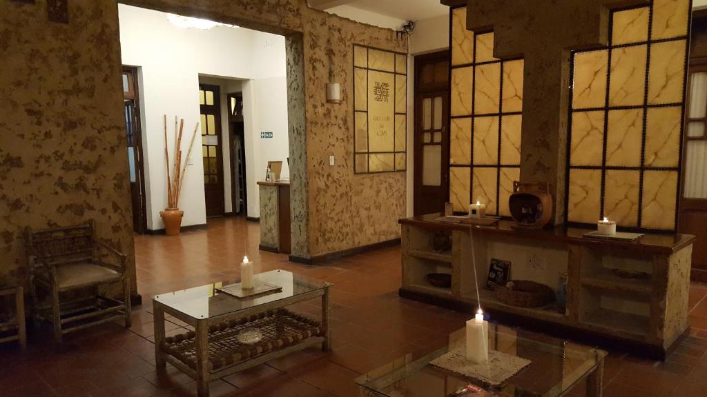 萨尔塔雷富希奥德尔印加酒店的客厅设有桌子和窗户,配有蜡烛
