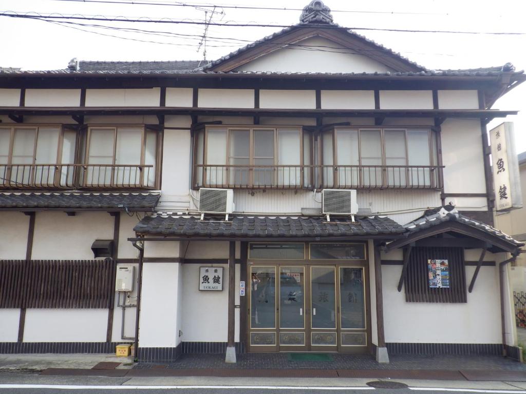 名古屋鱼键旅馆的白色的建筑,设有两个阳台和两个窗户