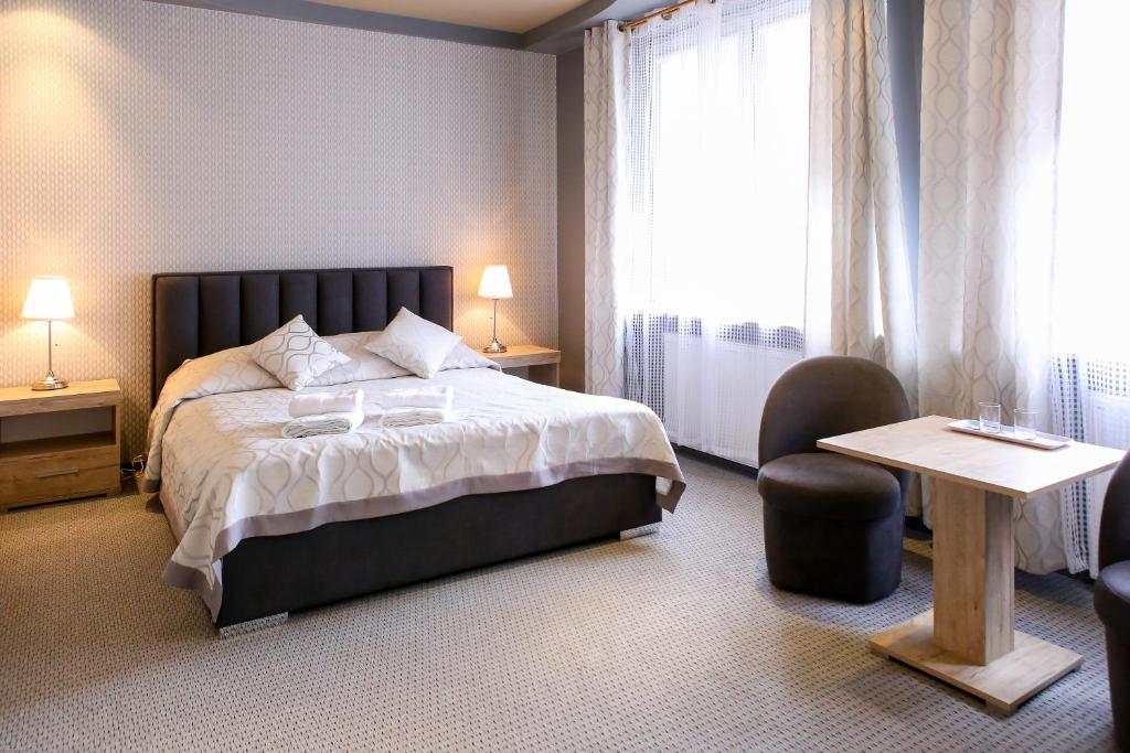 比亚韦斯托克索斯诺维扎西斯泽公寓式酒店的卧室配有床、椅子和窗户。