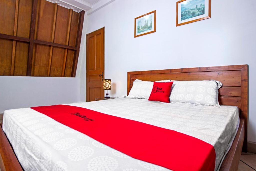 万隆RedDoorz Plus near Parahyangan University的一间卧室配有一张带红白毯子的床